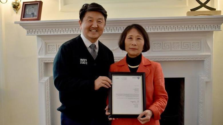 365英国上市杜波依斯分校 chancellor and chief academic officer Jungwoo Ryoo, 正确的, presents Pingjuan Werner with a framed copy of the letter certifying her as a distinguished professor, the highest professorial distinction at the University