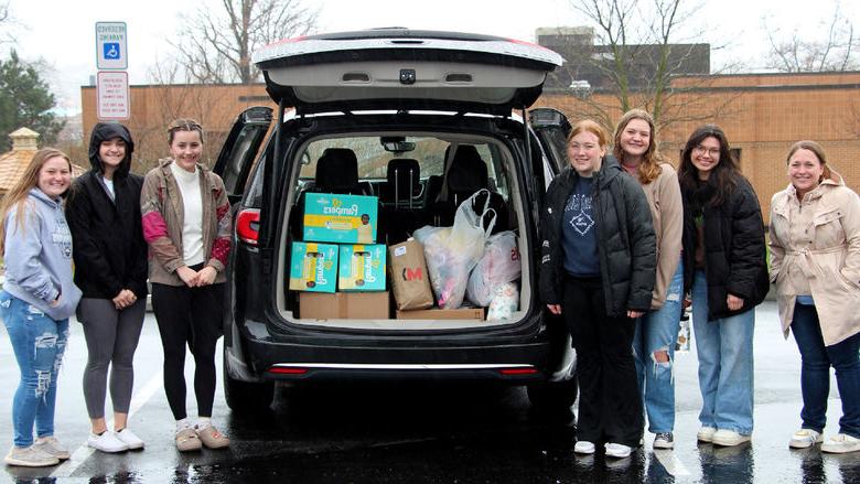 Members of the HDFS club at Penn State DuBois stand next to the vehicle loaded with their donation items prior to their trip to the Hello Neighbor location in Pittsburgh.